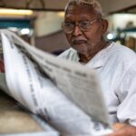 man-reading-newspaper-frustrated